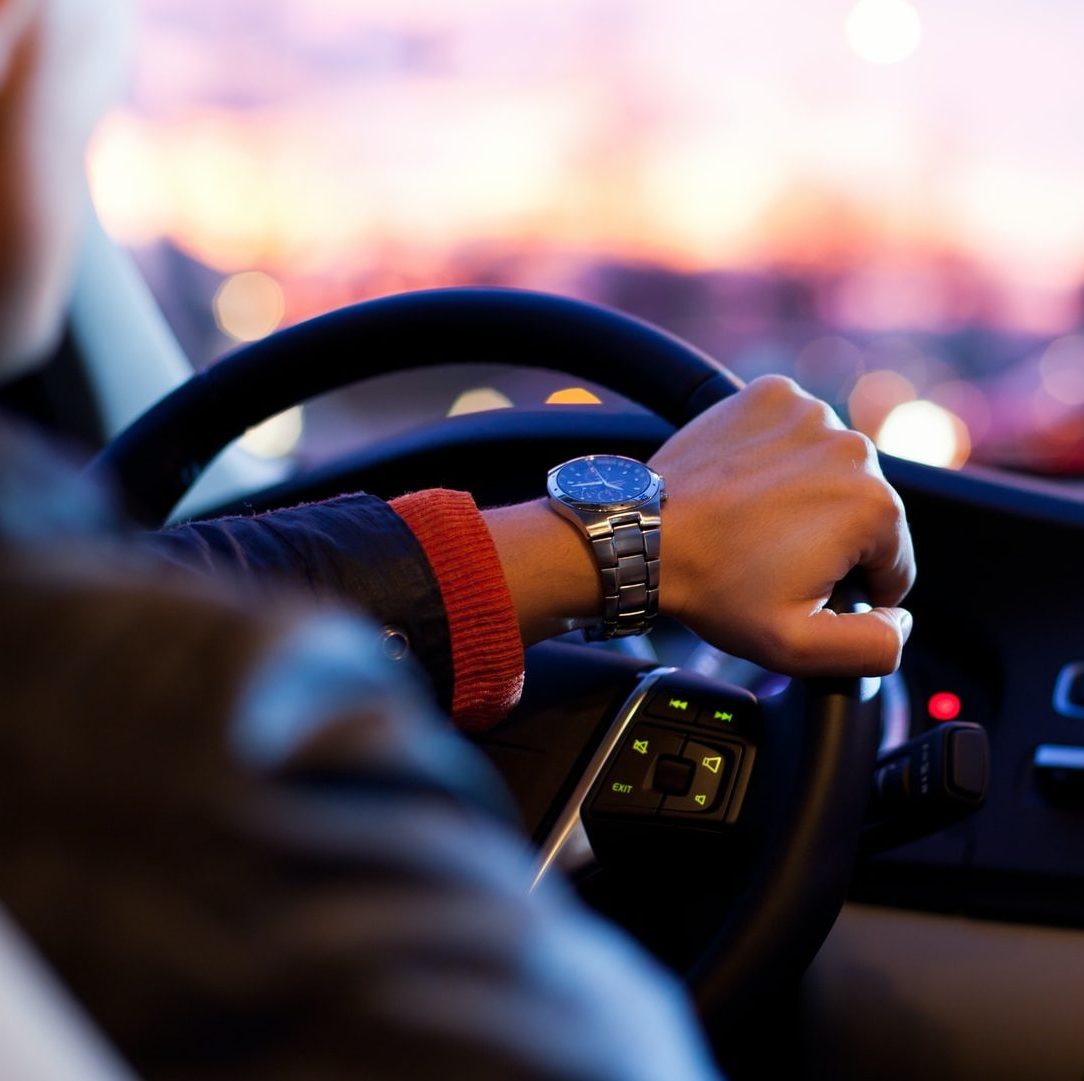 man driving a car wearing wrist watch